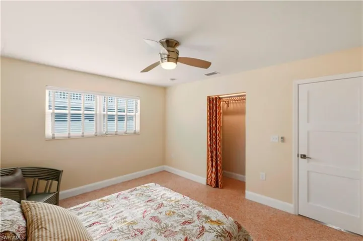Bedroom with a ceiling fan and light colored carpet