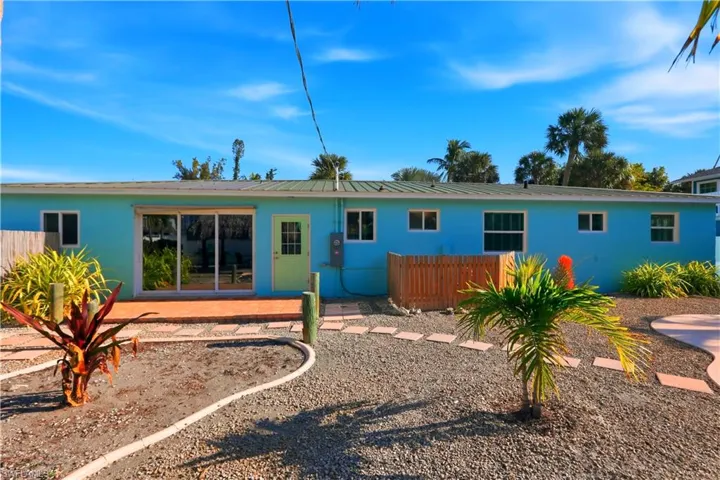Rear view of house with stucco siding and a metal roof