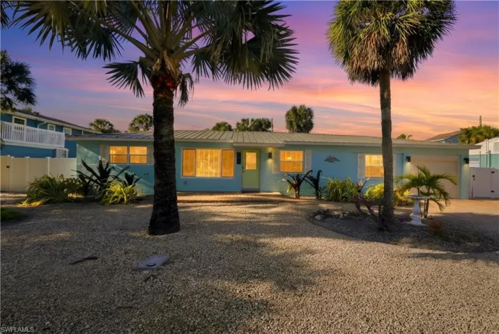 View of front of house featuring a gate, driveway, a garage, and a metal roof
