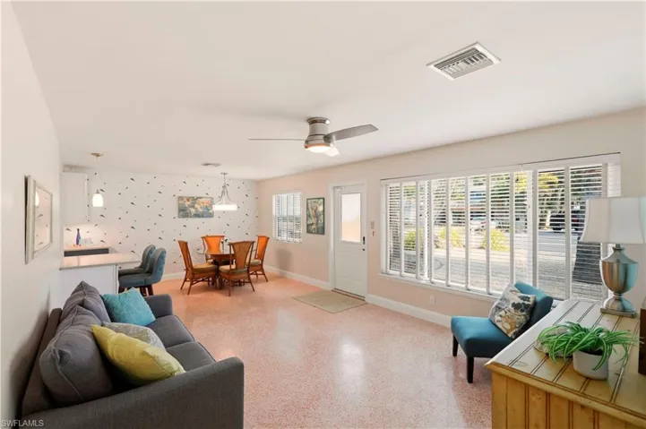 Living area with ceiling fan and dark aggregate flooring