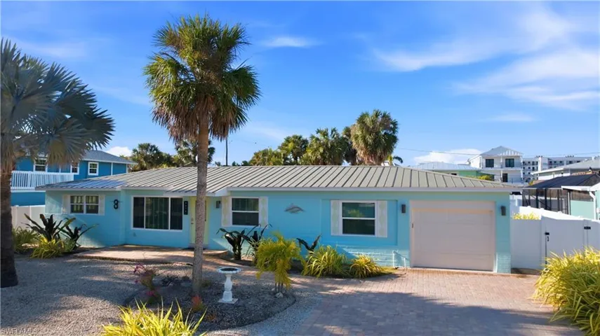 View of front of property with a gate, an attached garage, a metal roof, decorative driveway, and stucco siding