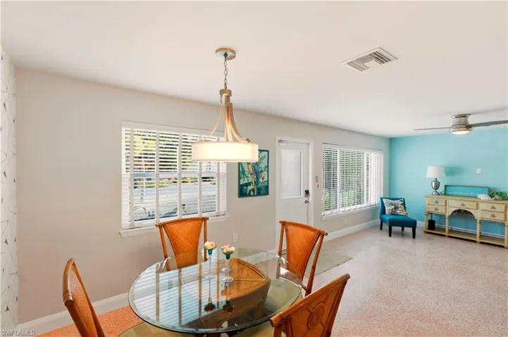 Dining area with dark aggregate flooring and ceiling fan