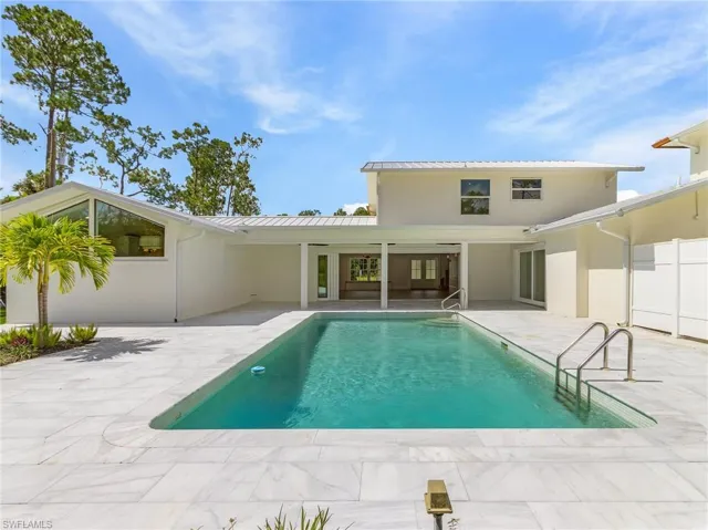 Rear view of house featuring an outdoor pool, a patio area, a metal roof, and stucco siding