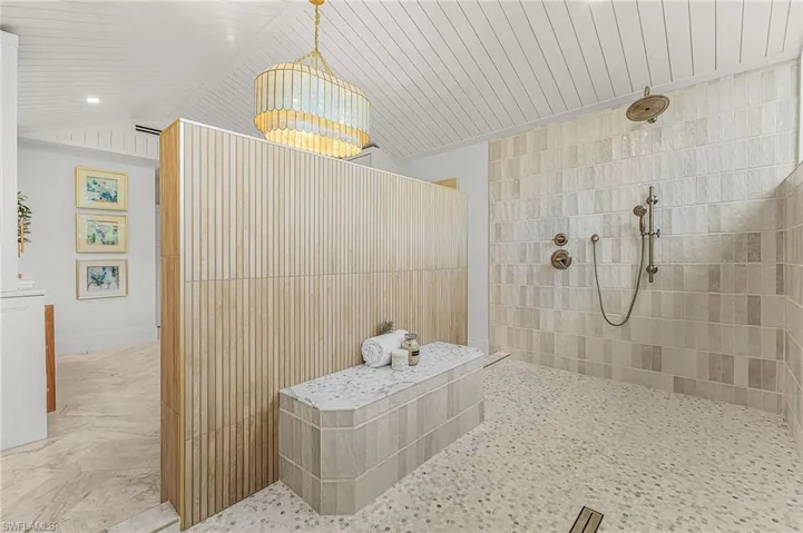 Bathroom featuring walk in shower and lofted ceiling
