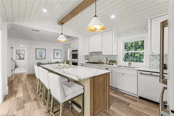 Kitchen with white cabinetry, light stone countertops, light wood finished floors, pendant lighting, and recessed lighting