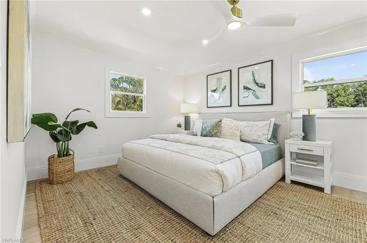 Bedroom with ceiling fan, wood finished floors, and crown molding
