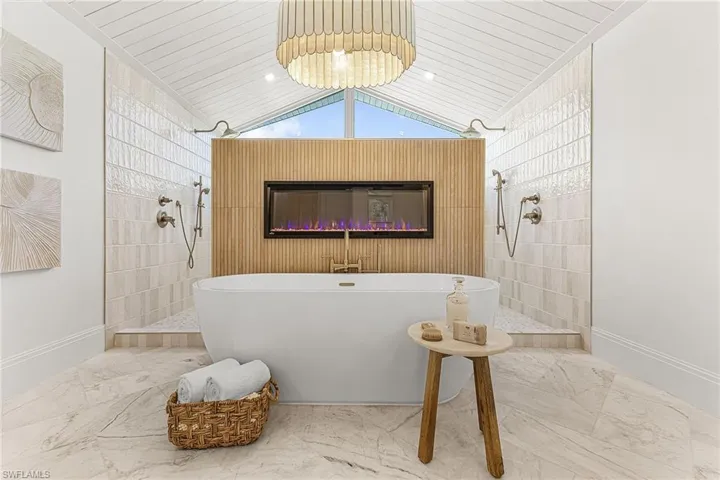 Bathroom featuring walk in shower, lofted ceiling, a freestanding bath, marble finish floors, and wood ceiling