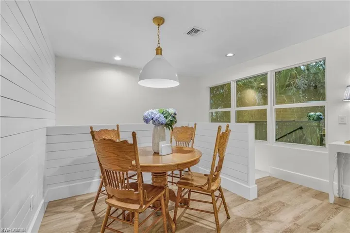 Dining space with wood finished floors, wood walls, and recessed lighting