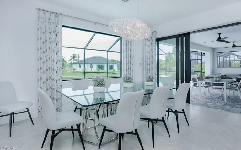 Dining room featuring a wealth of natural light, ceiling fan with notable chandelier, and light tile patterned flooring