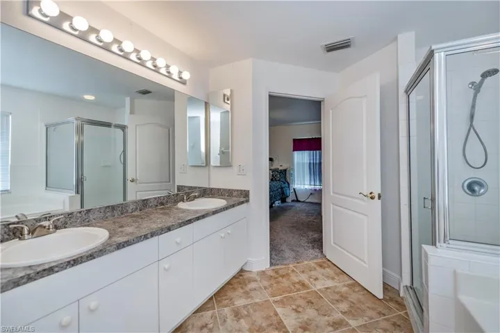 Bathroom featuring independent shower and bath, vanity, and tile patterned floors