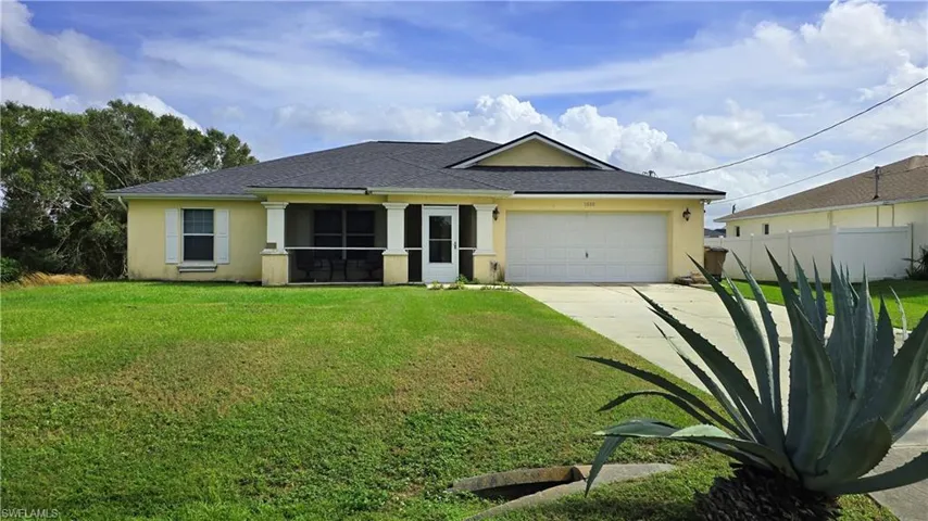 View of front of property featuring a garage and a front lawn