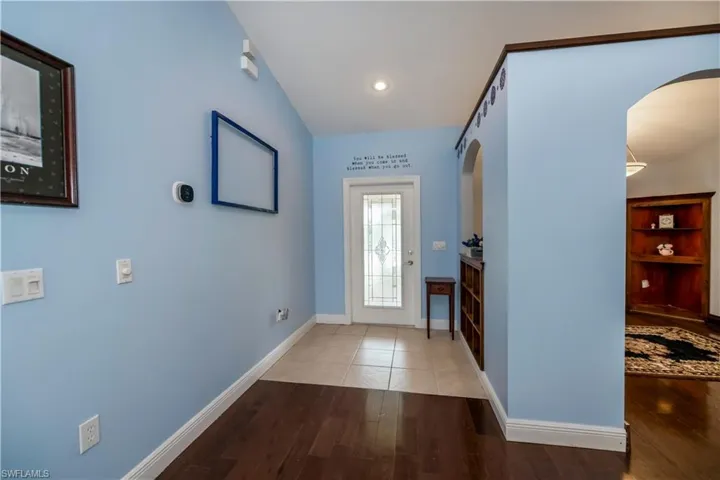 Entrance foyer with hardwood / wood-style floors and vaulted ceiling