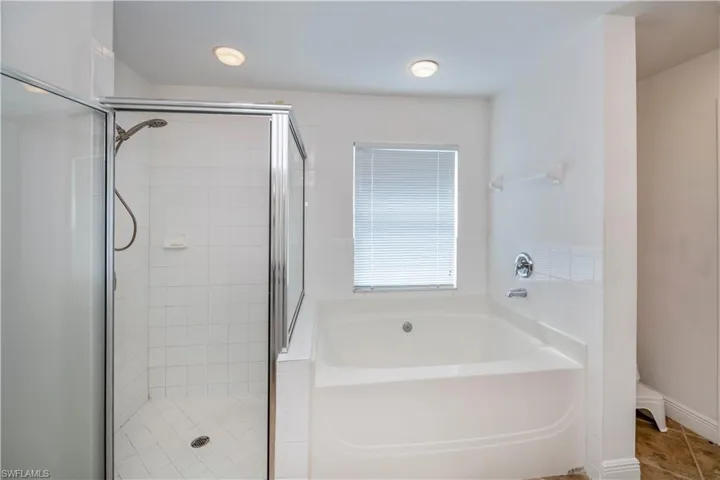 Bathroom with independent shower and bath and tile patterned flooring
