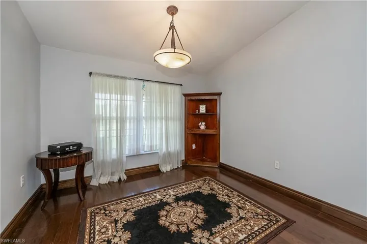 Sitting room featuring dark wood-type flooring and vaulted ceiling