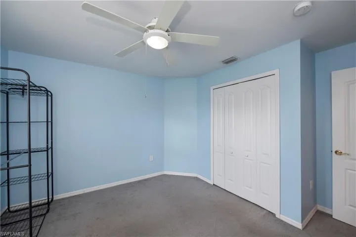 Unfurnished bedroom featuring a closet, carpet flooring, and ceiling fan