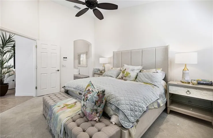 Carpeted bedroom featuring a high ceiling and ceiling fan
