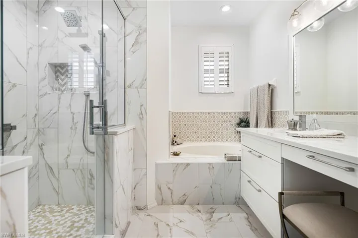 Bathroom featuring independent shower and bath and vanity