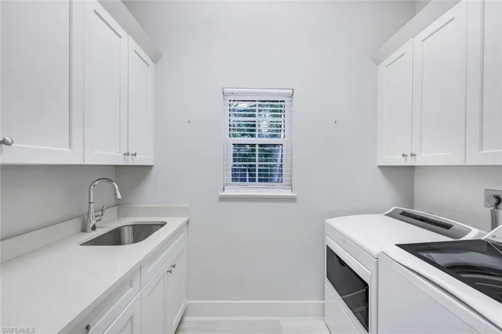 HUGE laundry room featuring plenty of storage.