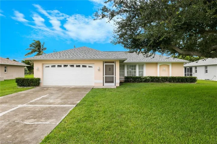 Ranch-style house featuring a garage and a front yard
