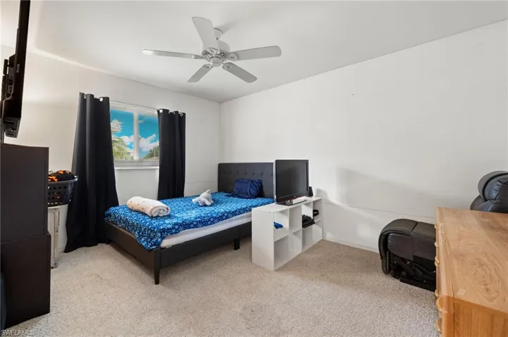 2nd Bedroom with light carpet and ceiling fan