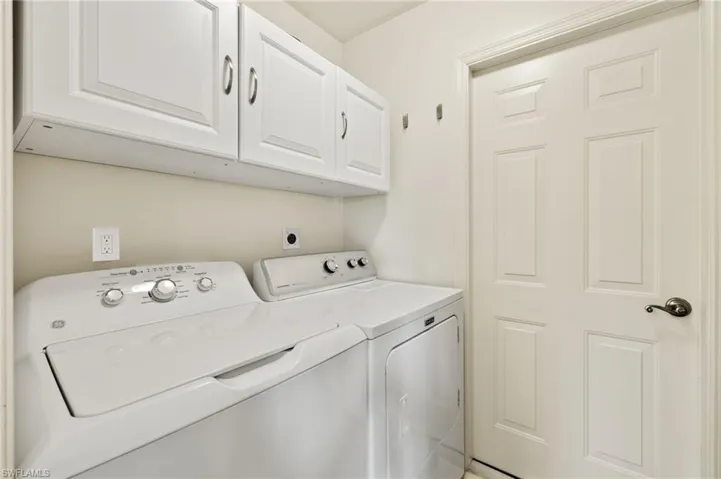 Laundry area featuring cabinets and washer and dryer
