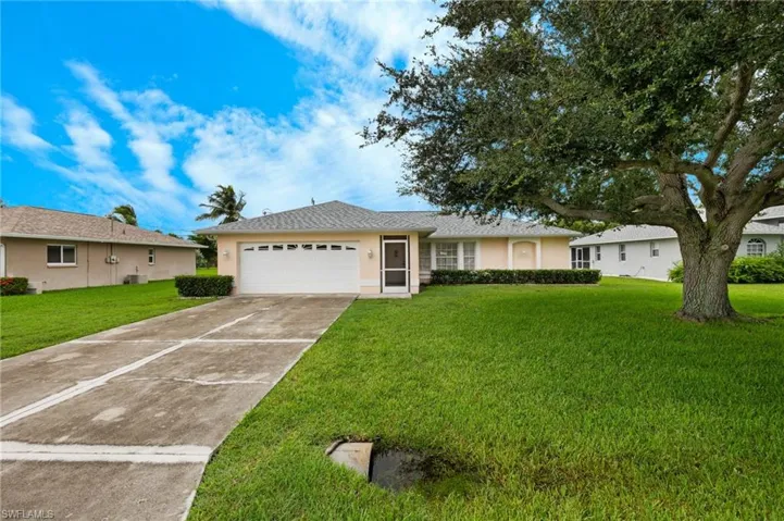 Single story home with a garage and a front yard