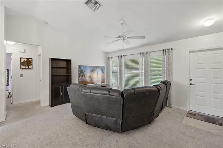 Living room with light carpet, high vaulted ceiling, and ceiling fan