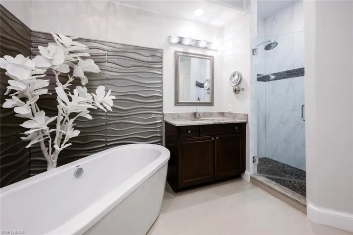 Walk in Tile Shower and separate sinks with custom cabinets, granite counter tops and designer lighting and mirrors
