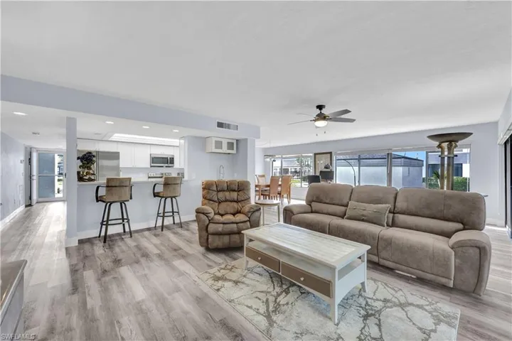 Living room featuring a ceiling fan, light wood-style floors, and recessed lighting