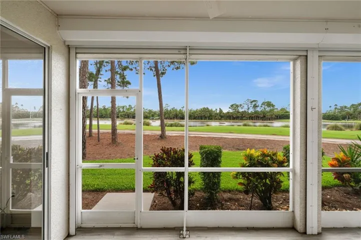 Unfurnished sunroom featuring a water view and view of scattered trees