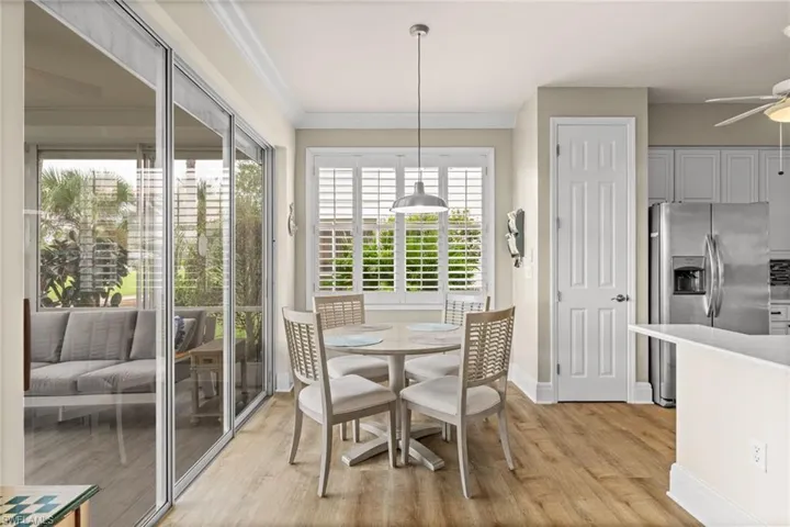 Dining room featuring light wood-type flooring, ceiling fan, and ornamental molding