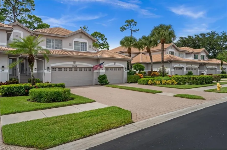 View of front of property with decorative driveway, stucco siding, and a tiled roof