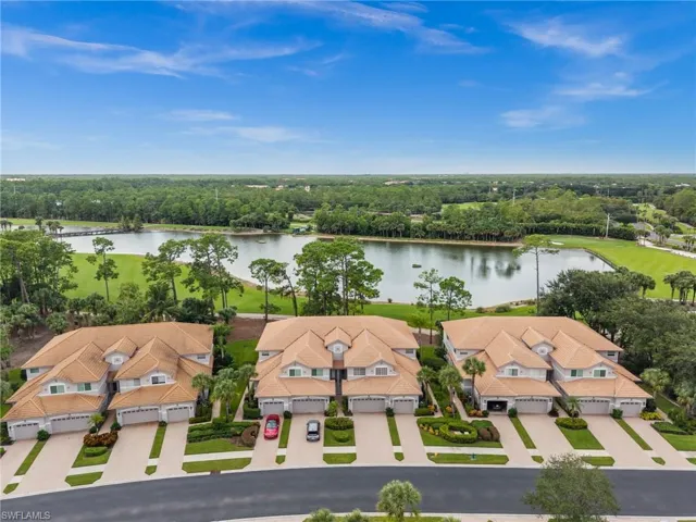 Aerial view of residential area featuring a large body of water and a tree filled landscape