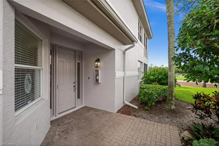 View of exterior entry featuring stucco siding and covered porch