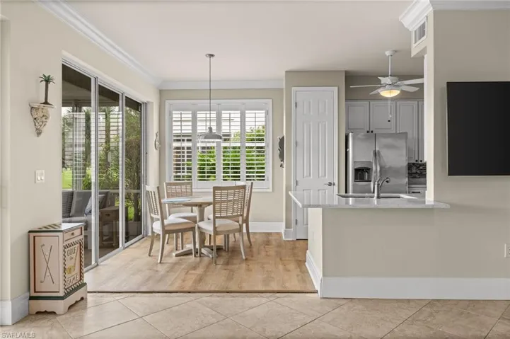 Dining space featuring light tile patterned floors, ornamental molding, and ceiling fan