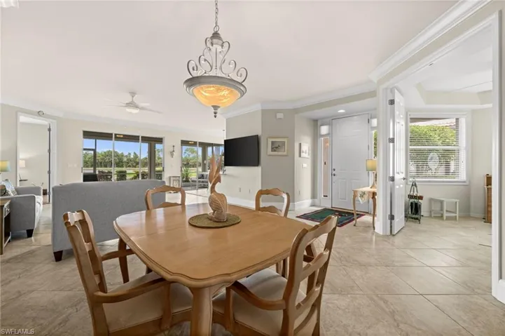 Dining space featuring crown molding, light tile patterned floors, and a ceiling fan