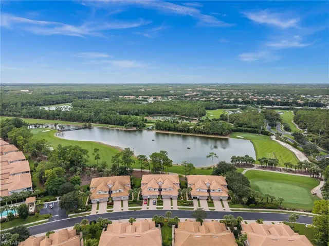 Aerial view of property's location with a nearby body of water, nearby suburban area, and a local golf course