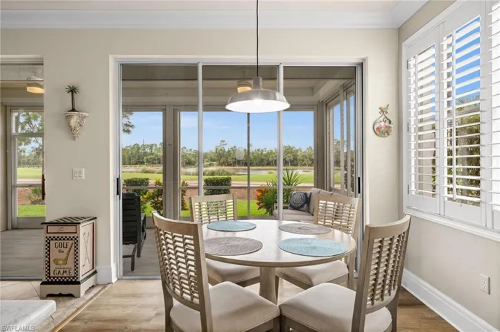 Dining area featuring wood finished floors, golf course view, crown molding, and a water view