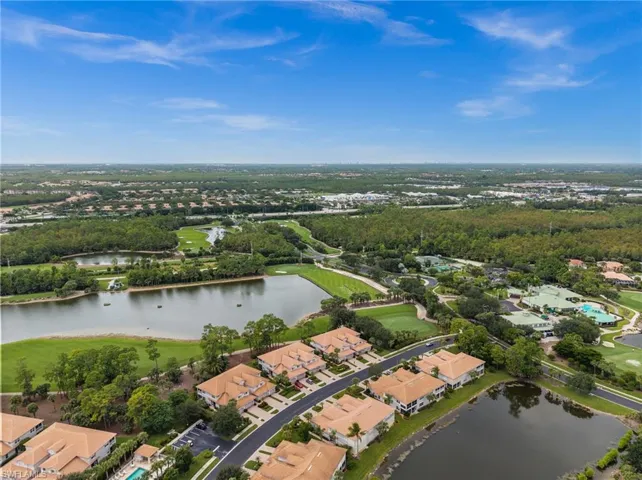 View of property location featuring a nearby body of water, nearby suburban area, and a golf club