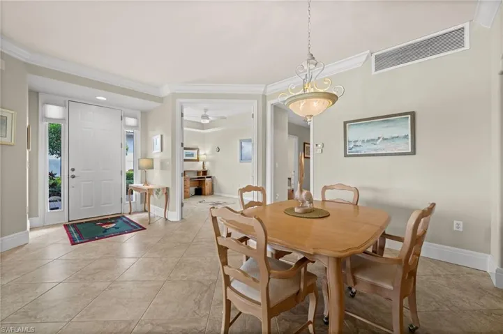 Dining area featuring ornamental molding, light tile patterned floors, and ceiling fan