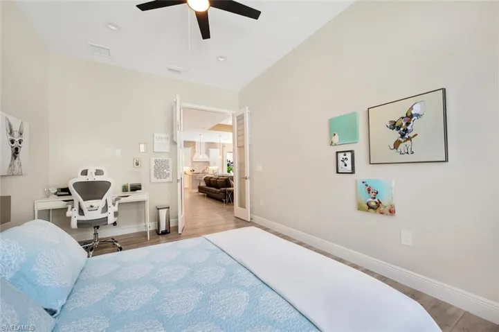 Bedroom with light wood-type flooring, vaulted ceiling, and ceiling fan