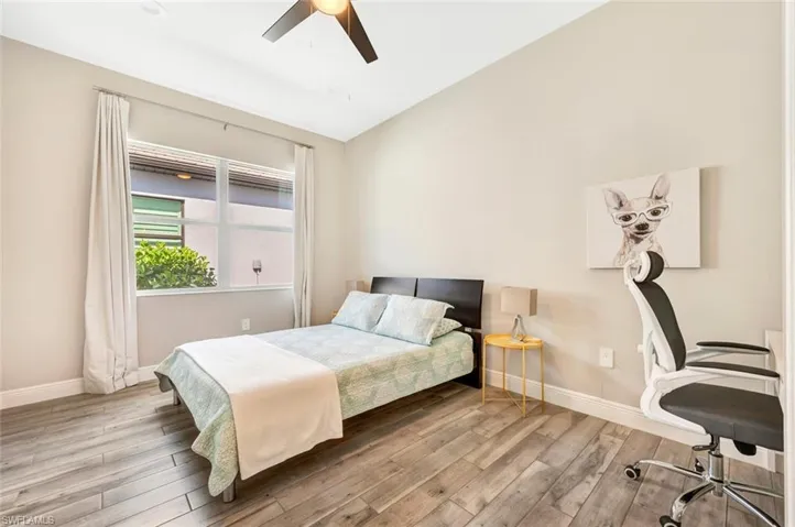 Bedroom featuring ceiling fan, vaulted ceiling, and light wood-type flooring