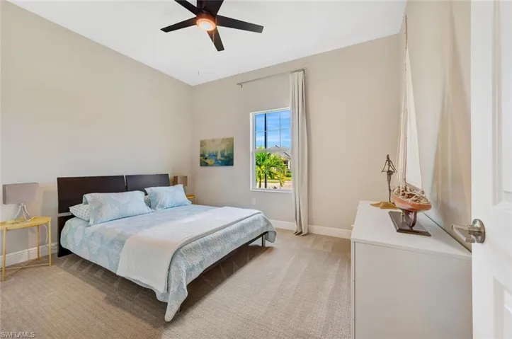 Carpeted bedroom featuring ceiling fan