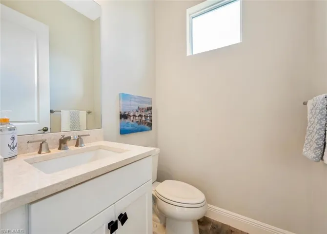 Bathroom with hardwood / wood-style flooring, oversized vanity, and toilet