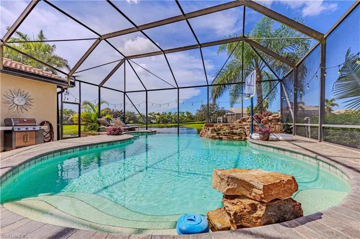 View of swimming pool featuring a patio, glass enclosure, and area for grilling