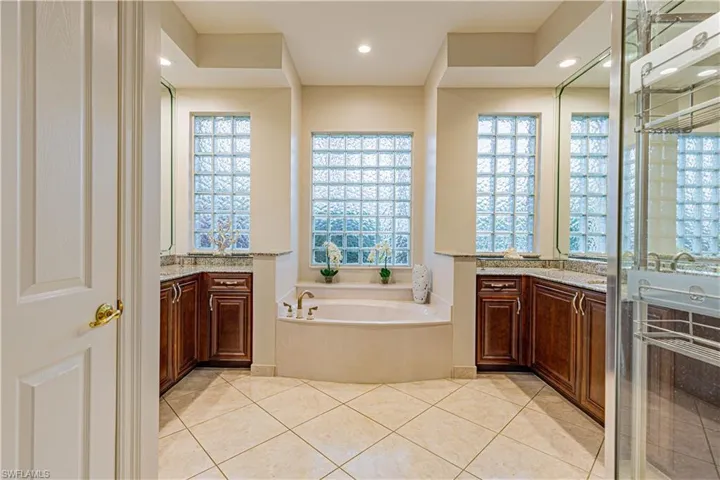 Bathroom featuring tile patterned flooring, a bath, plenty of natural light, and vanity
