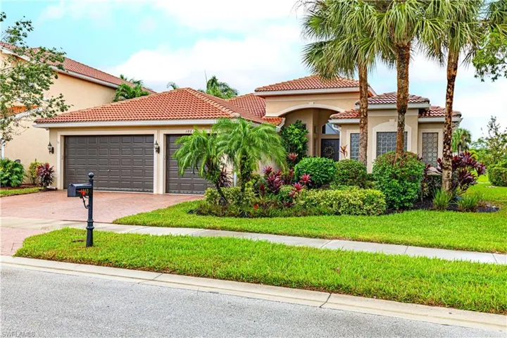 Mediterranean / spanish-style home featuring a garage and a front lawn
