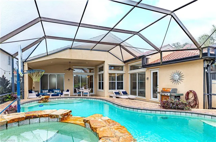 View of pool featuring ceiling fan, an in ground hot tub, a lanai, and a patio area