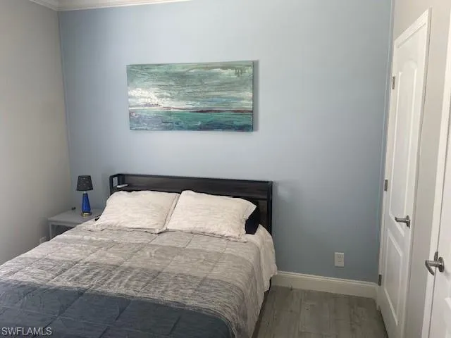 Bedroom with baseboards and wood finished floors