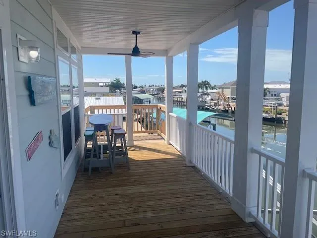 Wooden deck with a ceiling fan and a water view